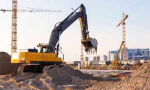 Excavator and cranes working on a large civil engineering site under development for drainage and stormwater design