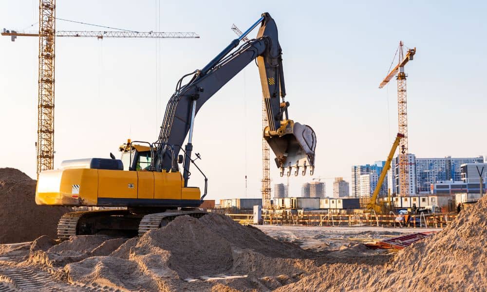 Stormwater design large scale site development - ALTA SURVEY Texas Excavator and cranes working on a large civil engineering site under development for drainage and stormwater design