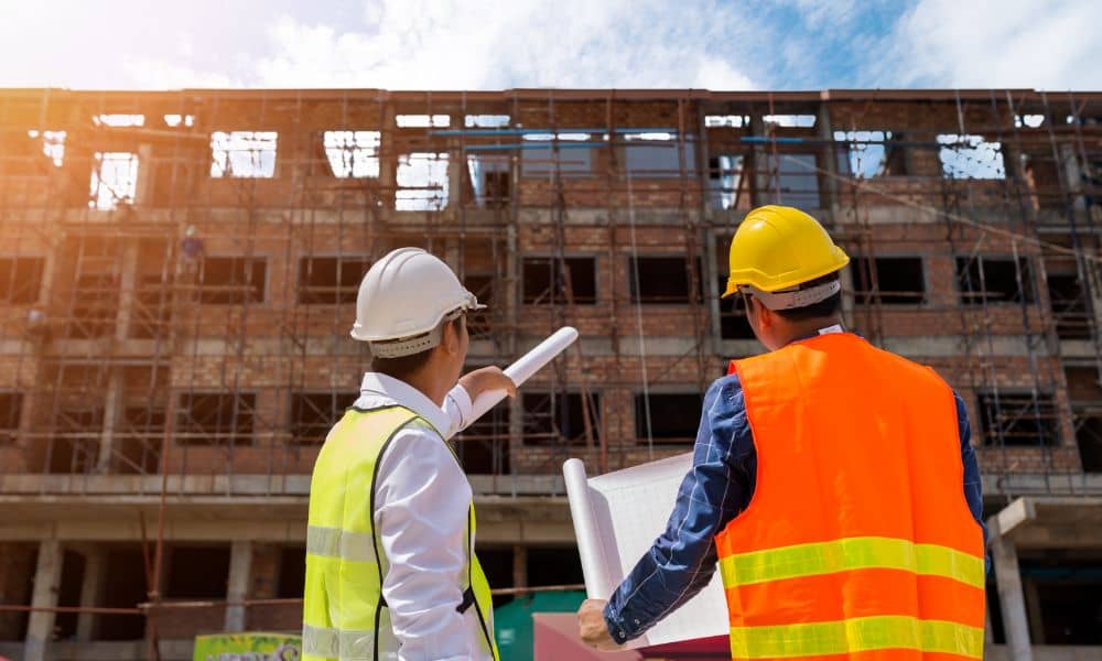 structural engineer - ALTA SURVEY Texas Structural engineering professionals reviewing building plans at a construction site with scaffolding in Weatherford, Texas