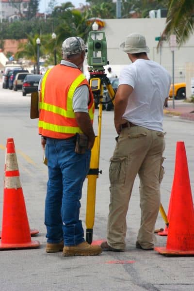 Construction survey safety road - ALTA SURVEY Texas Construction survey crew using equipment on a road with safety cones and traffic management