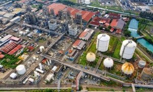 A wide aerial view taken during drone surveying, showing tanks, pipelines, and complex structures across a large industrial site
