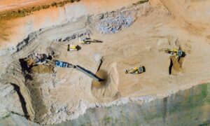 Aerial view of early stage land development with heavy equipment preparing a large project site reviewed by a civil engineering firm