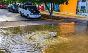 Urban engineering example of street flooding around a storm drain after heavy rain