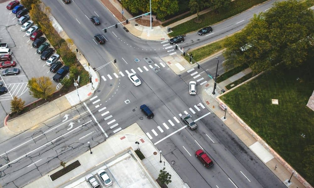 Aerial view of cars moving through a busy intersection showing traffic flow and turning patterns at a signalized crossing