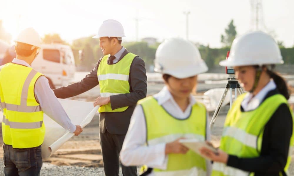 A surveyor and team reviewing site plans before a commercial replat to check boundaries and layout