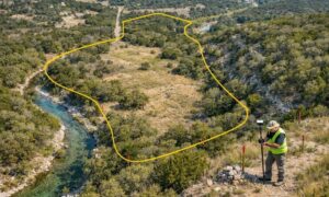 Surveyor assessing an irregular Hill Country property for a boundary survey cost estimate