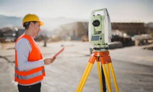 Licensed land surveyor using a total station while preparing survey data for an Austin property project