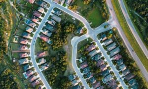 Aerial view of residential homes, streets, and property lots for a mortgage closing survey involving shared water service