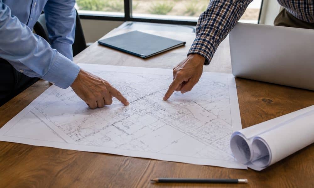 Two people reviewing a plat of survey for a property
